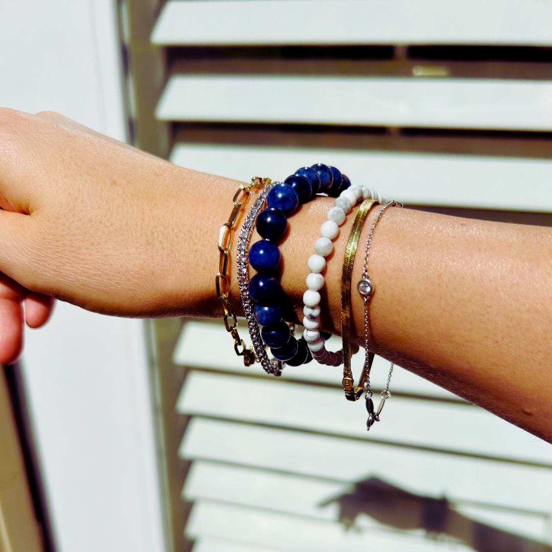 sodalite bracelet stack with gold bracelets and diamonds